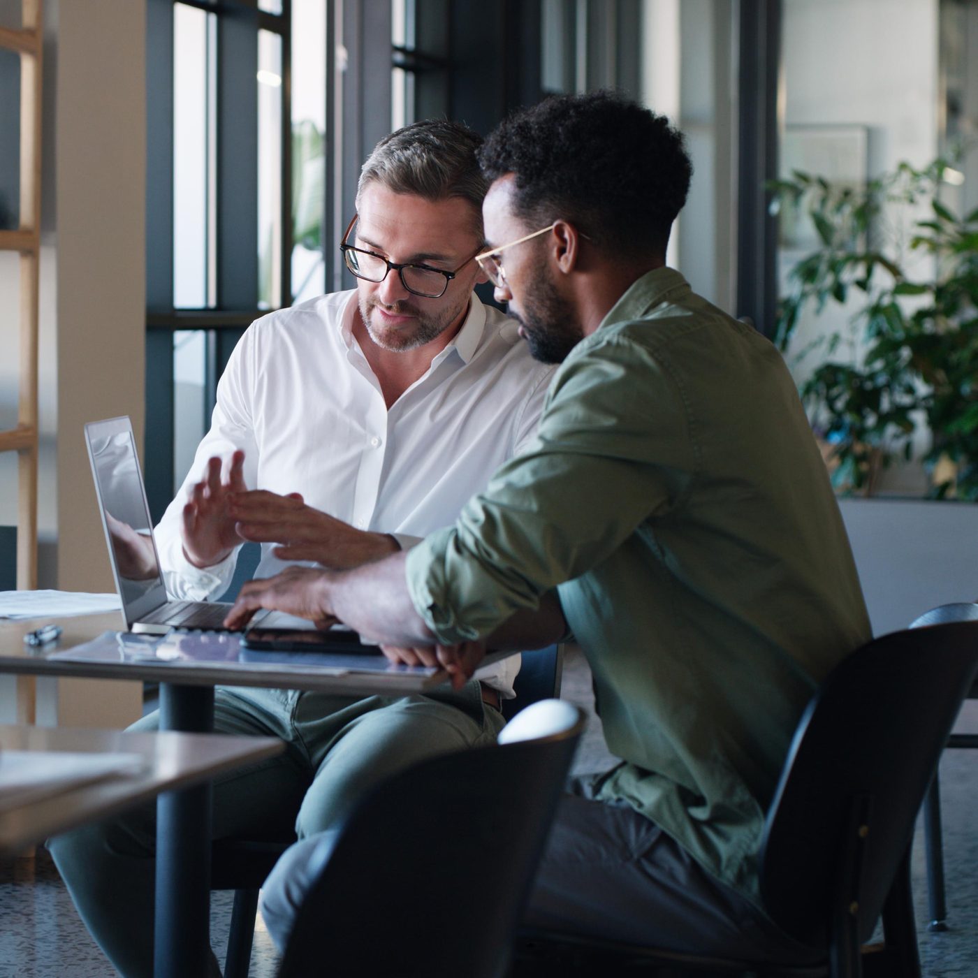 Two men in discussion at a laptop