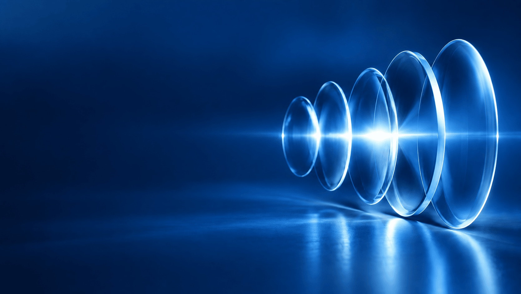 Glass lenses refracting a beam of blue light